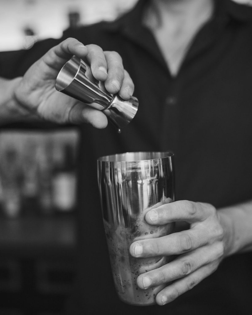Barman at work in the pub making cocktails. Black and white photo